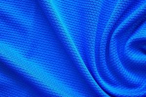 Blue football jersey clothing fabric texture sports wear background, close up top view photo