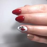 manicura femenina roja en las uñas de cerca foto