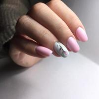 professional pink female manicure on nails close up photo