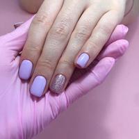 Manicure of different colors on nails. Female manicure on the hand on pink background photo