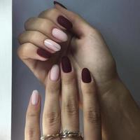 Closeup of hands of a young woman with pink and red manicure on nails photo