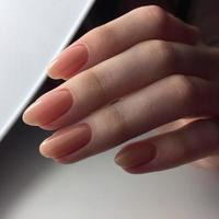 manos femeninas con elegante manicura rosa sobre fondo blanco foto