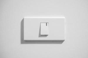 white lighting switch on concrete wall background photo