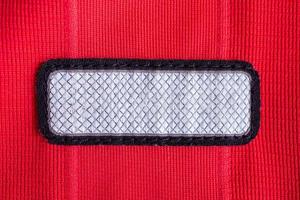 blank clothes tag label on red polyester sport jersey shirt texture background photo