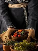 A vertical shot of a chef serving a gourmet salad dish photo