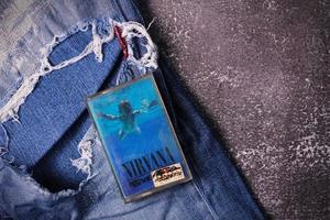 WASHINGTON, USA - September 30 2022  Nirvana's cassette tape and Ripped jeans or Torn jeans. A symbol of the grunge or Seattle sound. photo