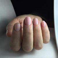 manicura - uñas de mujer bellamente cuidadas con bonito esmalte de uñas rosa foto