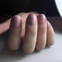 Stylish trendy female pink manicure.Hands of a woman with pink manicure on nails photo