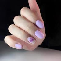 elegante manicura rosa femenina de moda. manos de una mujer con manicura rosa en las uñas foto