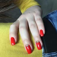 Closeup photo of a beautiful female hands with red nail