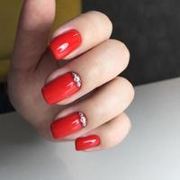 Closeup photo of a beautiful female hands with red nail