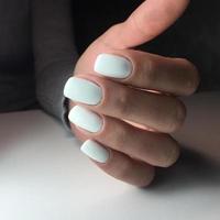 Woman's hands with white nails on the dark background photo