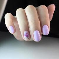 elegante manicura rosa femenina de moda. manos de una mujer con manicura rosa en las uñas foto