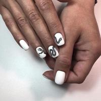 manicura femenina. manicura con diseño de serpiente en las uñas. foto