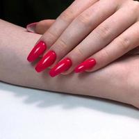 mano con manicura de uñas rojas foto