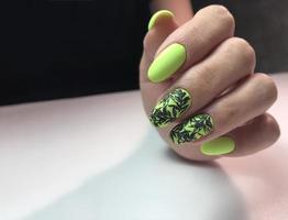 stylish design of green manicure on beautiful nails photo