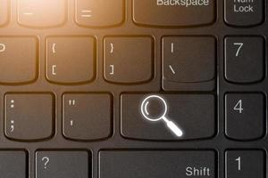 Search icon symbol on the computer key board with computer light , searching online technology concept copy space for individual text and design photo