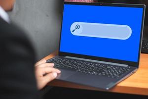 A business man in the office, using laptop for searching information on the internet, computer and search technology concept photo