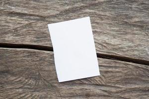 Blank white paper on old rustic wood table background photo