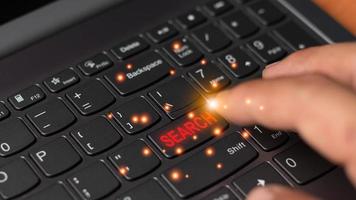 A hand hit on the search keyboard button, searching technology online concept. computer graphic light with copy space for text and design photo