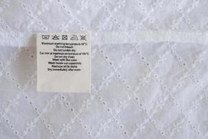 laundry care washing instructions clothes label on fabric texture background photo