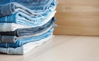 denim blue jeans stack on wood table background photo