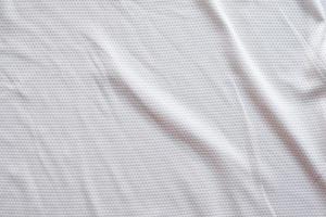 camiseta de fútbol de ropa deportiva de tela blanca con fondo de textura de malla de aire foto