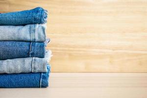 denim blue jeans stack on wood table background photo