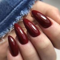 elegante manicura femenina roja de moda. manos de una mujer con manicura roja en las uñas foto