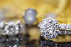 anillos de diamantes de joyería de oro de lujo con reflejo en el fondo negro foto