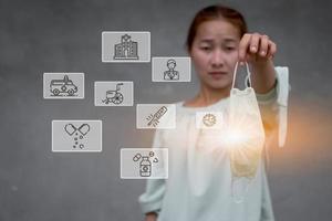 A women holding the mask with computer graphic light and virus hospital related icon around photo