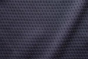 camiseta de fútbol de ropa deportiva de tela negra con fondo de textura de malla de aire foto