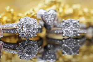 anillos de diamantes de joyería de oro de lujo con reflejo en el fondo negro foto