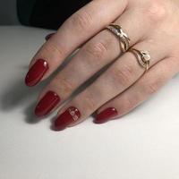 elegante manicura femenina roja de moda. manos de una mujer con manicura roja en las uñas foto