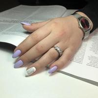 Stylish trendy female purple manicure with design.Hands of a woman with purple manicure on nails photo