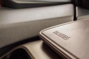 señal de seguridad del airbag en textura de cuero marrón en coche moderno foto