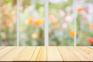 Empty wood table top with kitchen window abstract blur colorful rose flowers in the garden natural bokeh light background photo