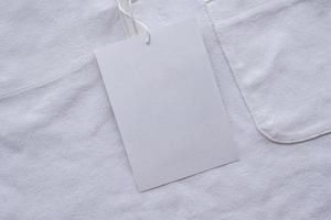 Blank white clothes tag label on new shirt photo