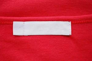 Blank white clothes tag label on new red shirt photo