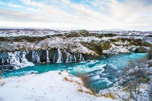 hraunfossar, una cascada formada por riachuelos que fluyen sobre hallmundarhraun, un campo de lava del volcán que se encuentra bajo el glaciar langjokull, y se vierte en el río hvita, islandia foto