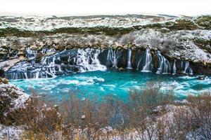 hraunfossar, una cascada formada por riachuelos que fluyen sobre hallmundarhraun, un campo de lava del volcán que se encuentra bajo el glaciar langjokull, y se vierte en el río hvita, islandia foto