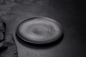 plato negro vacío sobre fondo de piedra oscura con espacio libre. vista superior foto