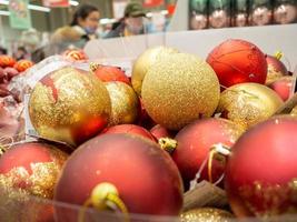 adornos navideños en la tienda. venta de regalos. buen espíritu de año nuevo. juguetes para el árbol de navidad. foto