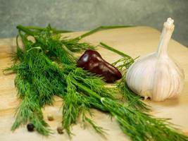 Still life on a black background. Multi-colored peppercorns ,  dill and garlic. photo