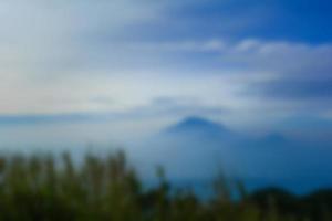 paisaje borroso cielo azul con nubes, hermoso fondo de paisaje de colores pastel de fantasía, cielo degradado, amanecer con montañas en la lejanía foto