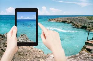 tourist taking photo of stone coastline of Caribbean Sea