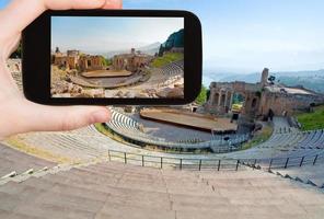 tourist taking photo of ancient amphitheater