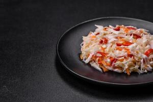 A delicious fresh vegetarian salad of white cabbage, carrot and paprika photo