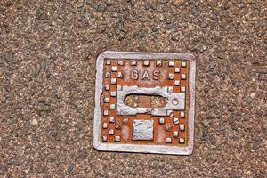 Manhole cover of the gas pipeline system. A massive metal hatch for access to city communications in the pavement. photo