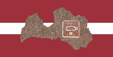 Outline map of Latvia with the image of the national flag. Manhole cover of the gas pipeline system inside the map. Collage. Energy crisis. photo